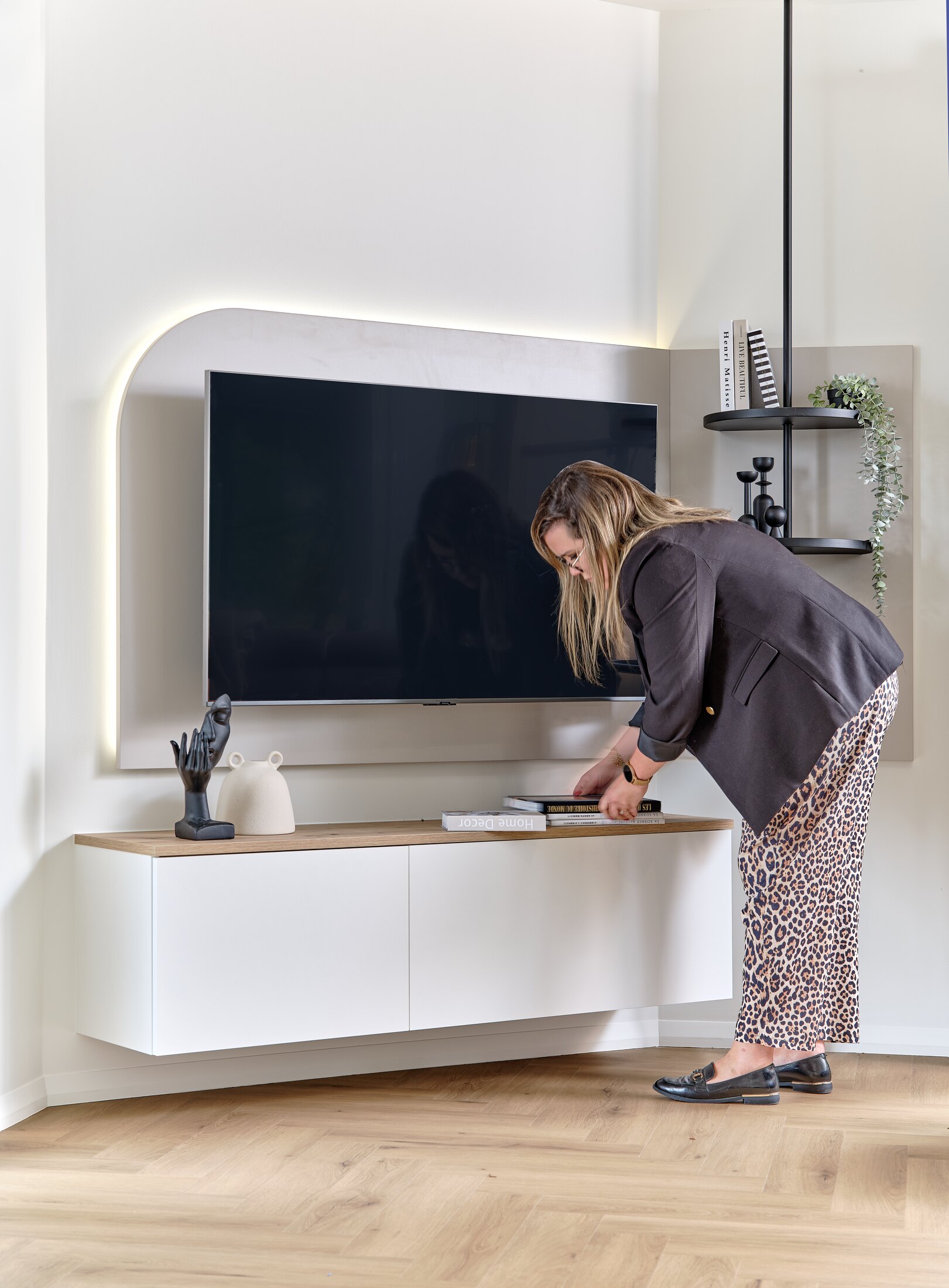 Charlène met en place les derniers éléments de décoration d’un meuble TV